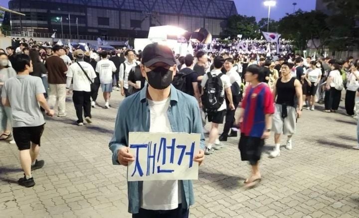 장동혁 국민의힘 대표가 지난 6일 서울 송파구 올림픽공원 핸드볼경기장에 설치된 개표소 앞에서 투표용지 부족 사태에 항의하며 재선거를 요구하는 손피켓을 들고 있다. (사진=장동혁 대표 SNS) 